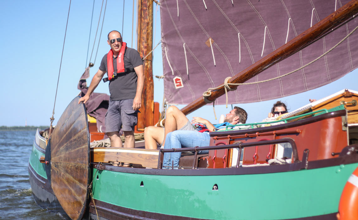Skipper Detlef Bothe an Bord der Twee Gebroeders unter Segeln auf dem Wasser